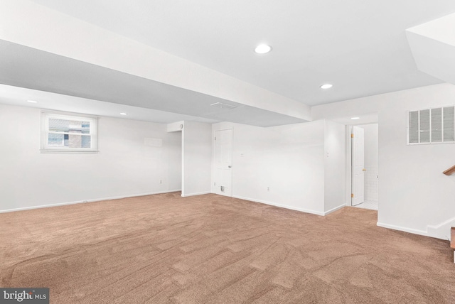 finished basement featuring light carpet, baseboards, visible vents, stairway, and recessed lighting