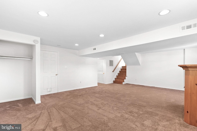 finished below grade area featuring visible vents, baseboards, stairway, carpet, and recessed lighting