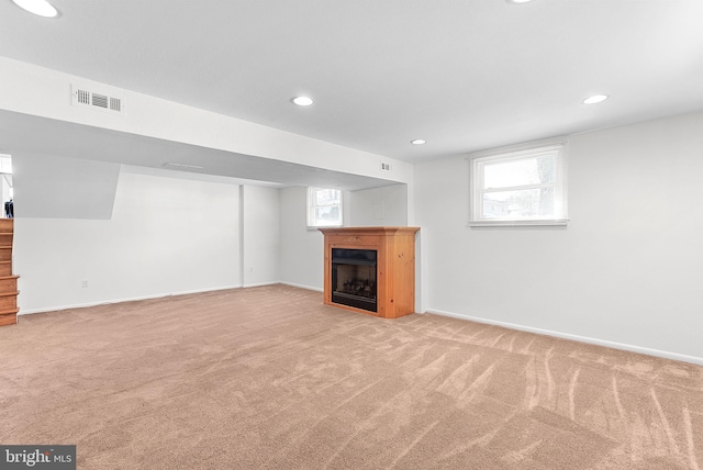 below grade area with recessed lighting, carpet floors, a fireplace, visible vents, and baseboards