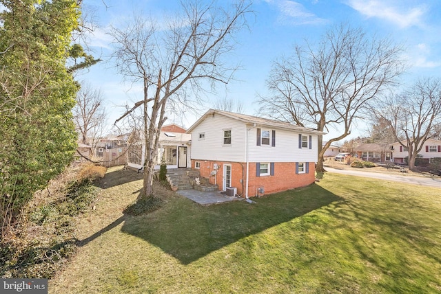 view of property exterior featuring brick siding and a lawn