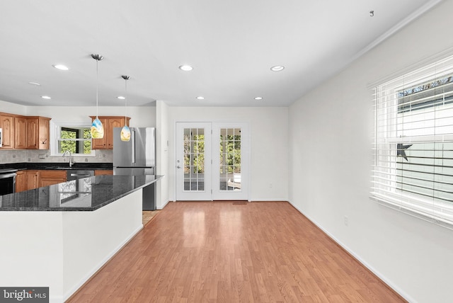 kitchen with recessed lighting, stainless steel appliances, decorative backsplash, light wood finished floors, and decorative light fixtures