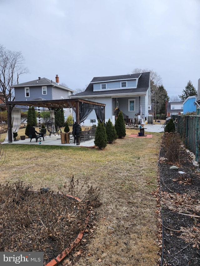 rear view of property featuring a lawn, a gazebo, a patio area, fence, and a pergola