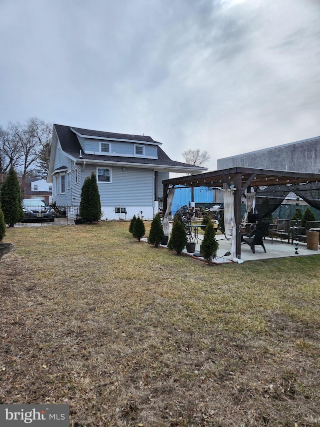 rear view of house with a lawn, fence, a patio, and a pergola