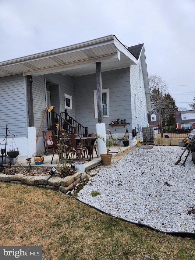 exterior space with a lawn, a patio area, fence, and central air condition unit