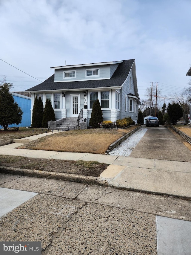 bungalow-style house featuring driveway and a shingled roof