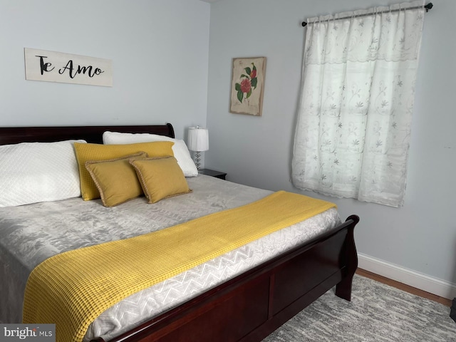 bedroom featuring baseboards and wood finished floors