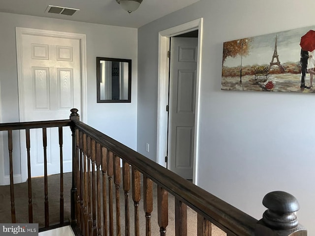 hallway with an upstairs landing and visible vents