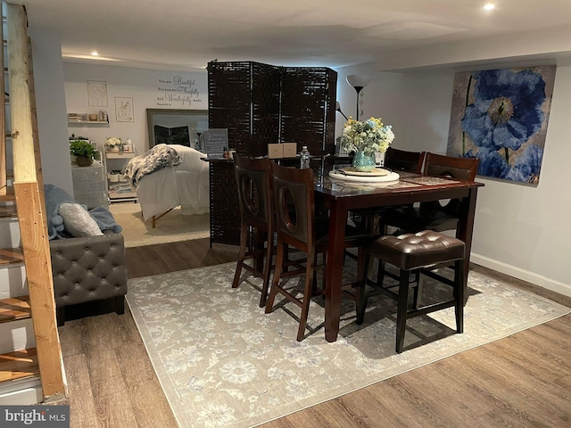 dining area with baseboards and wood finished floors