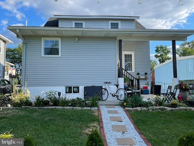 view of front of property featuring entry steps, a patio area, and a front yard