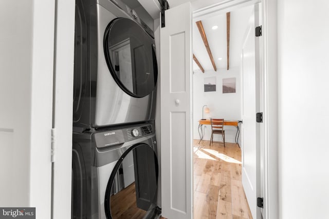 washroom featuring laundry area, stacked washer and dryer, hardwood / wood-style flooring, and recessed lighting