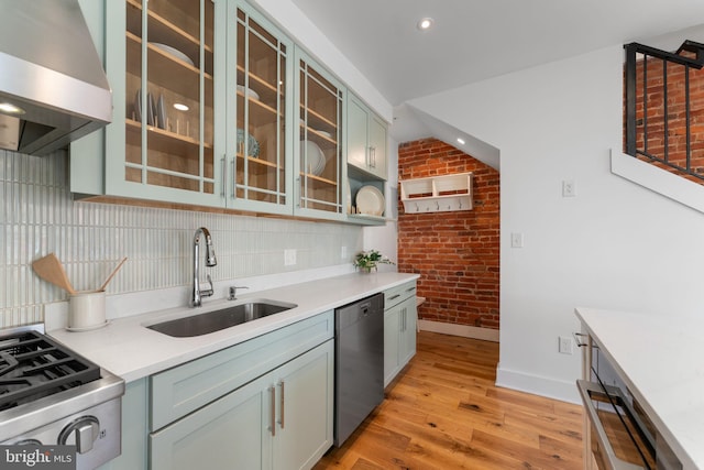 kitchen with extractor fan, a sink, stainless steel dishwasher, light wood-type flooring, and range