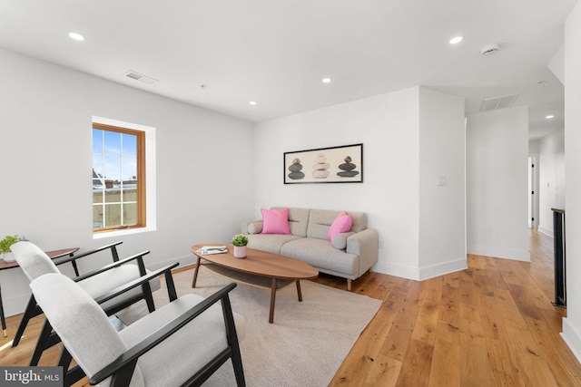 living area featuring light wood finished floors, baseboards, visible vents, and recessed lighting