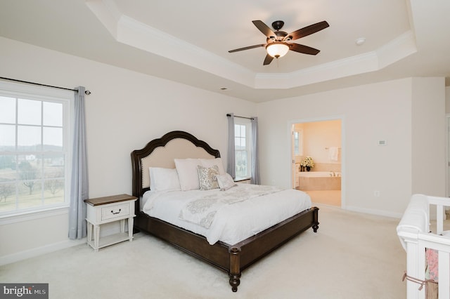 bedroom featuring light carpet, baseboards, a raised ceiling, connected bathroom, and ornamental molding