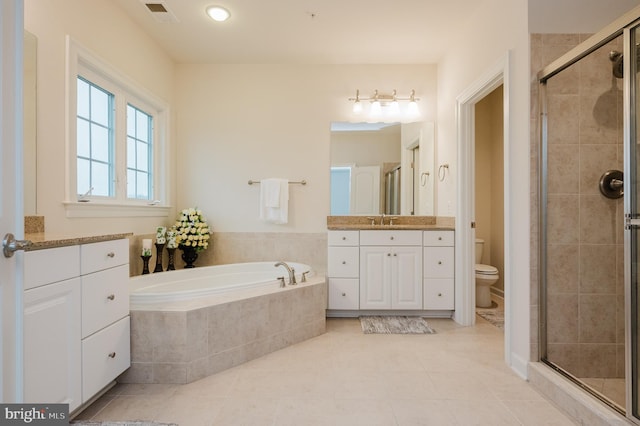 bathroom featuring toilet, vanity, visible vents, a bath, and a stall shower