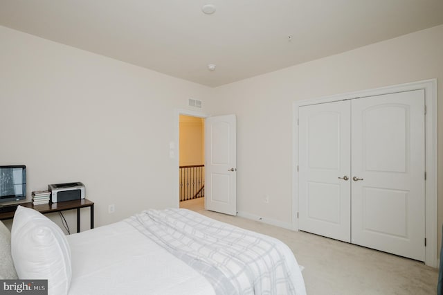 bedroom featuring light colored carpet, a closet, visible vents, and baseboards