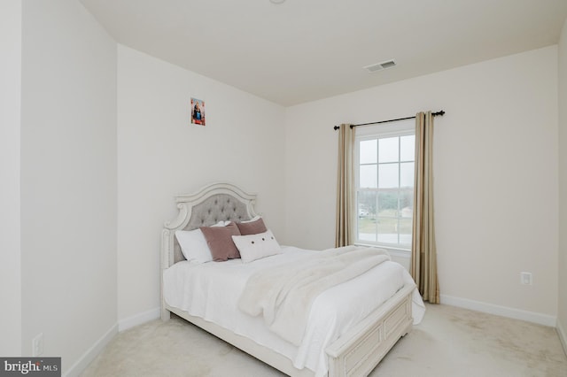 bedroom with light colored carpet, visible vents, and baseboards