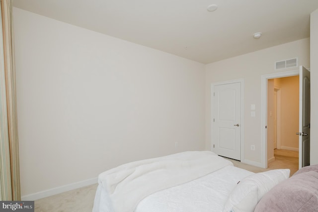 bedroom featuring baseboards, visible vents, and light colored carpet