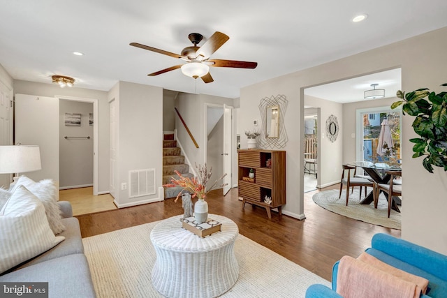 living area featuring stairway, a ceiling fan, wood finished floors, visible vents, and recessed lighting