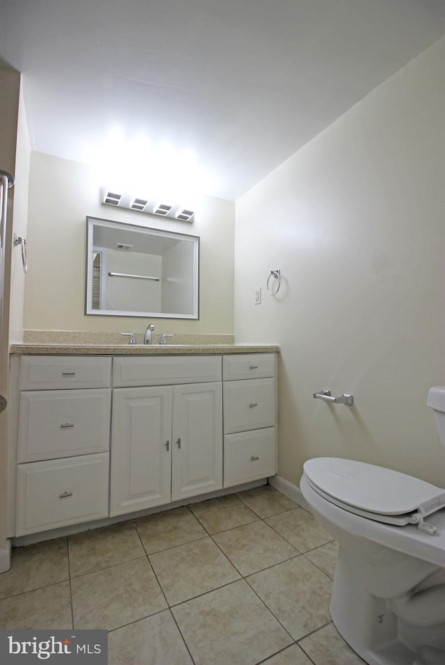 bathroom featuring vanity, tile patterned flooring, toilet, and baseboards