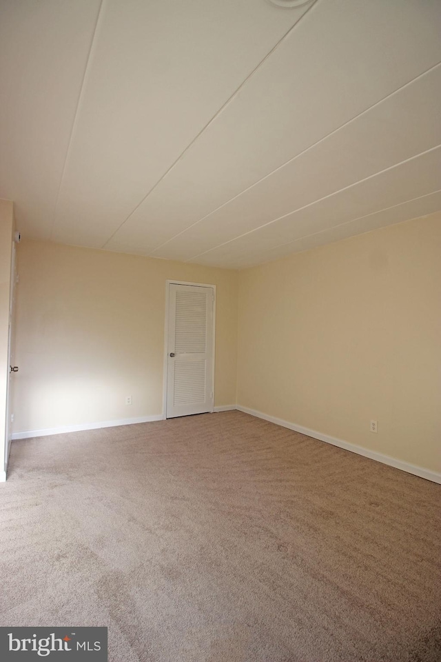 carpeted spare room with baseboards