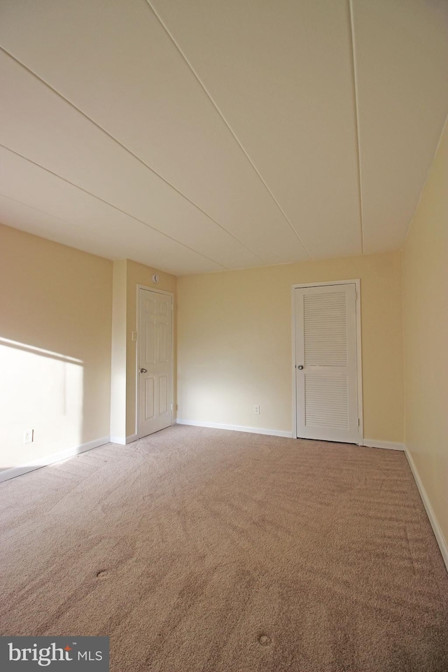 empty room featuring carpet and baseboards