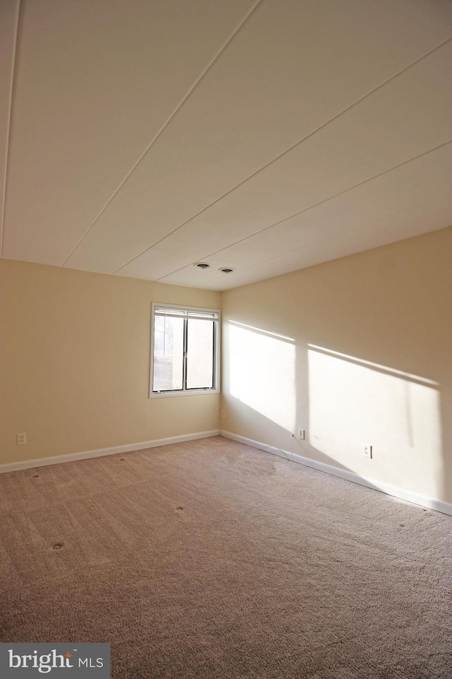 unfurnished room featuring baseboards and carpet flooring