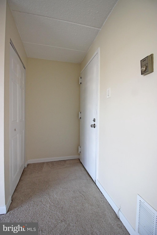 unfurnished bedroom with baseboards, a closet, visible vents, and light colored carpet