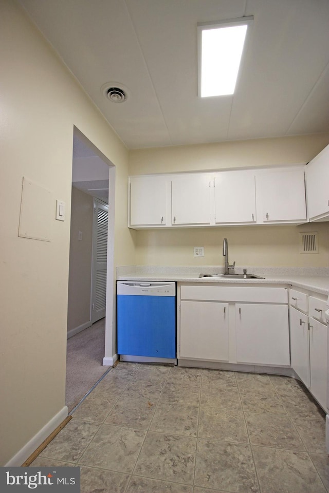 kitchen featuring white cabinets, visible vents, a sink, and dishwashing machine