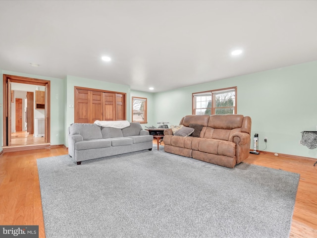 living area featuring light wood-style floors, baseboards, and recessed lighting