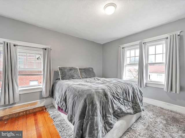 bedroom featuring a textured ceiling and baseboards