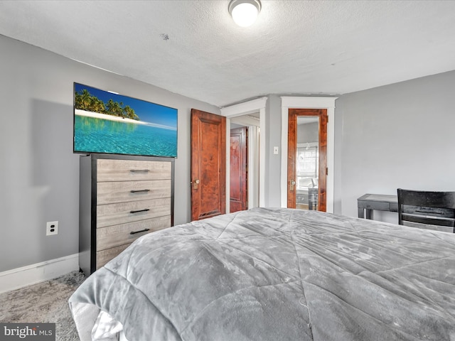 bedroom featuring a textured ceiling and baseboards