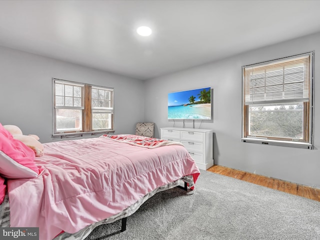 bedroom with multiple windows and light wood-type flooring