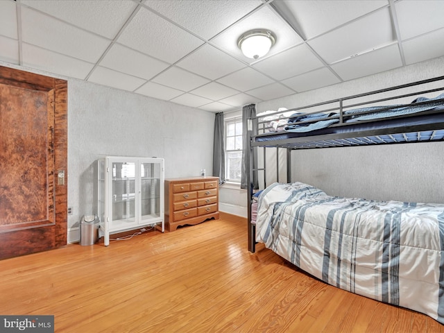 bedroom featuring a paneled ceiling and light wood-style floors