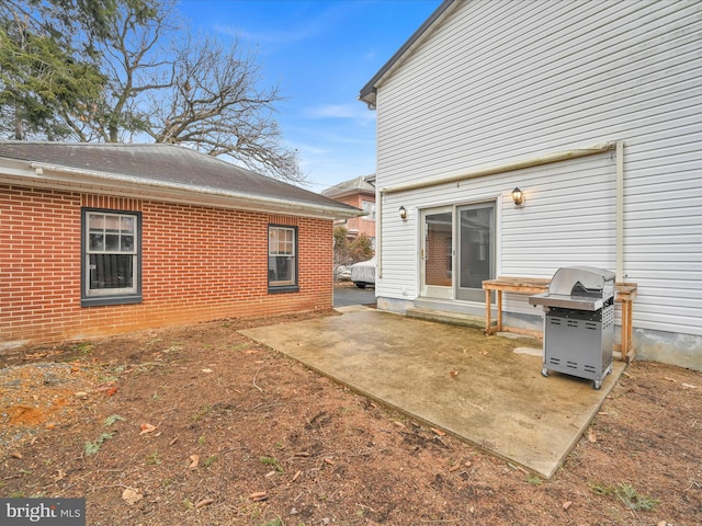 back of house with brick siding and a patio area