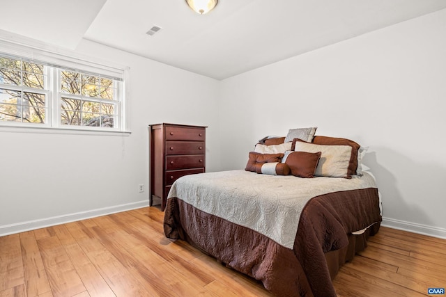 bedroom featuring light wood finished floors and baseboards