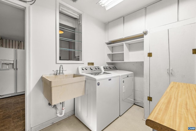 laundry room with a sink, laundry area, light tile patterned floors, and washing machine and dryer