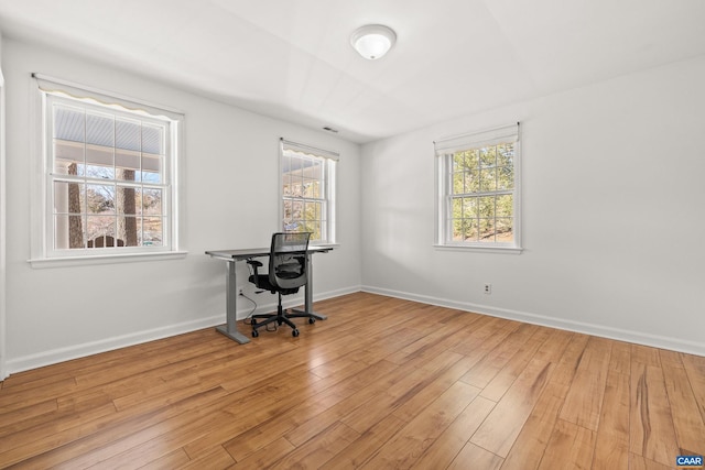 home office featuring visible vents, light wood-style flooring, and baseboards