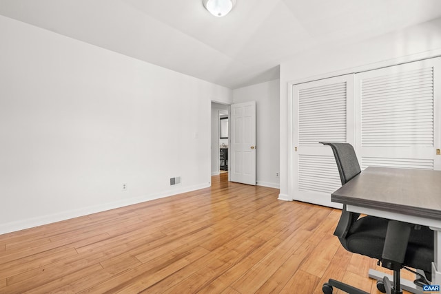 office with baseboards, visible vents, and light wood finished floors