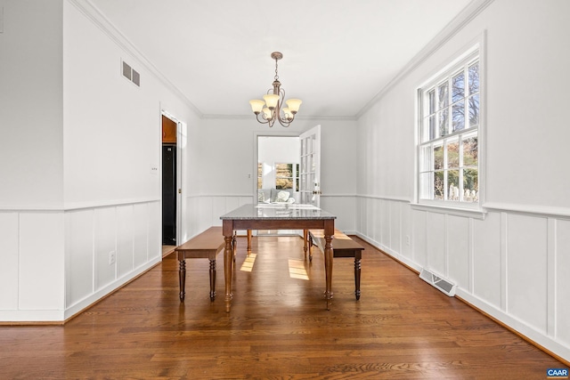 dining room featuring an inviting chandelier, visible vents, and wood finished floors