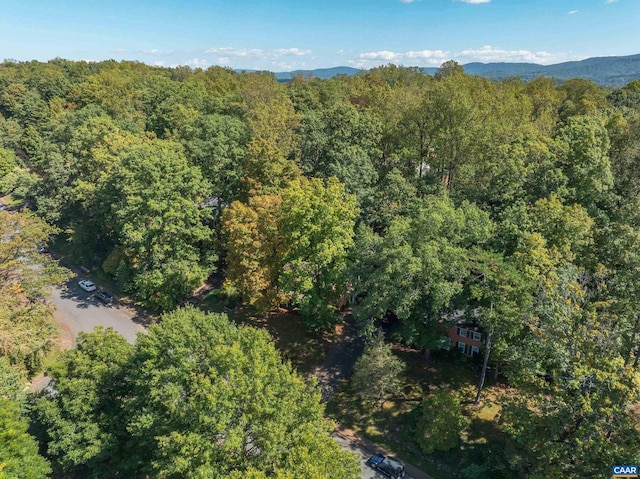 aerial view featuring a wooded view and a mountain view