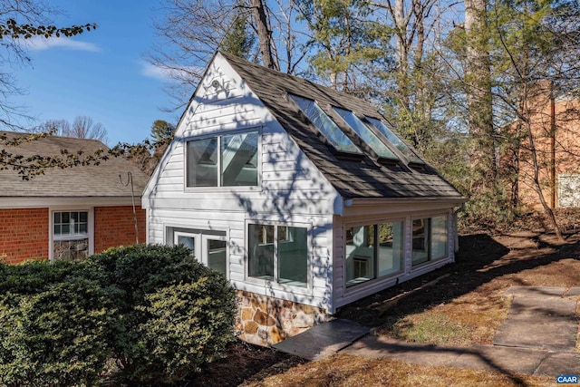 view of side of home with a shingled roof