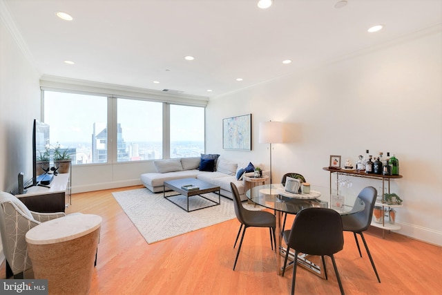 dining area featuring ornamental molding, light wood-type flooring, baseboards, and recessed lighting