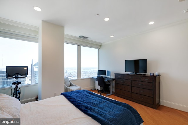 bedroom featuring visible vents, baseboards, ornamental molding, light wood-type flooring, and recessed lighting