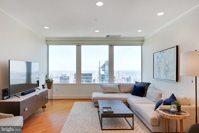 living room featuring a view of city, visible vents, crown molding, and light wood-style flooring