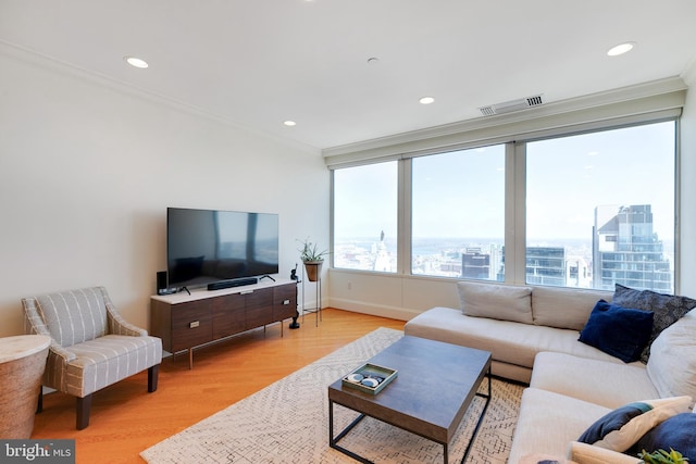 living area featuring ornamental molding, visible vents, and plenty of natural light