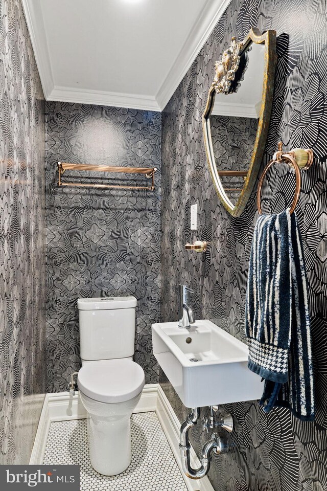 922 Clinton St, Philadelphia, PA 19107 - half bath with ornamental molding, toilet, a sink, wallpapered walls, and tile patterned flooring