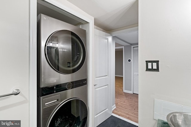 922 Clinton St, Philadelphia, PA 19107 - laundry area featuring stacked washer / drying machine, baseboards, and dark wood-style flooring