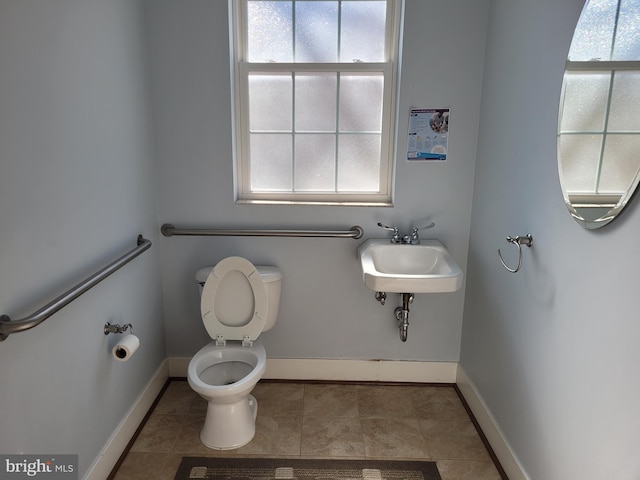 bathroom with plenty of natural light, a sink, tile patterned flooring, and baseboards