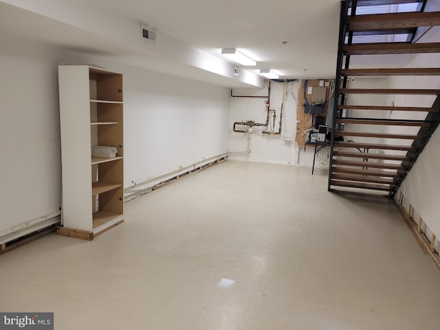 finished basement featuring visible vents and tile patterned floors