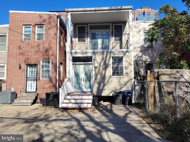 back of property with central AC unit and fence